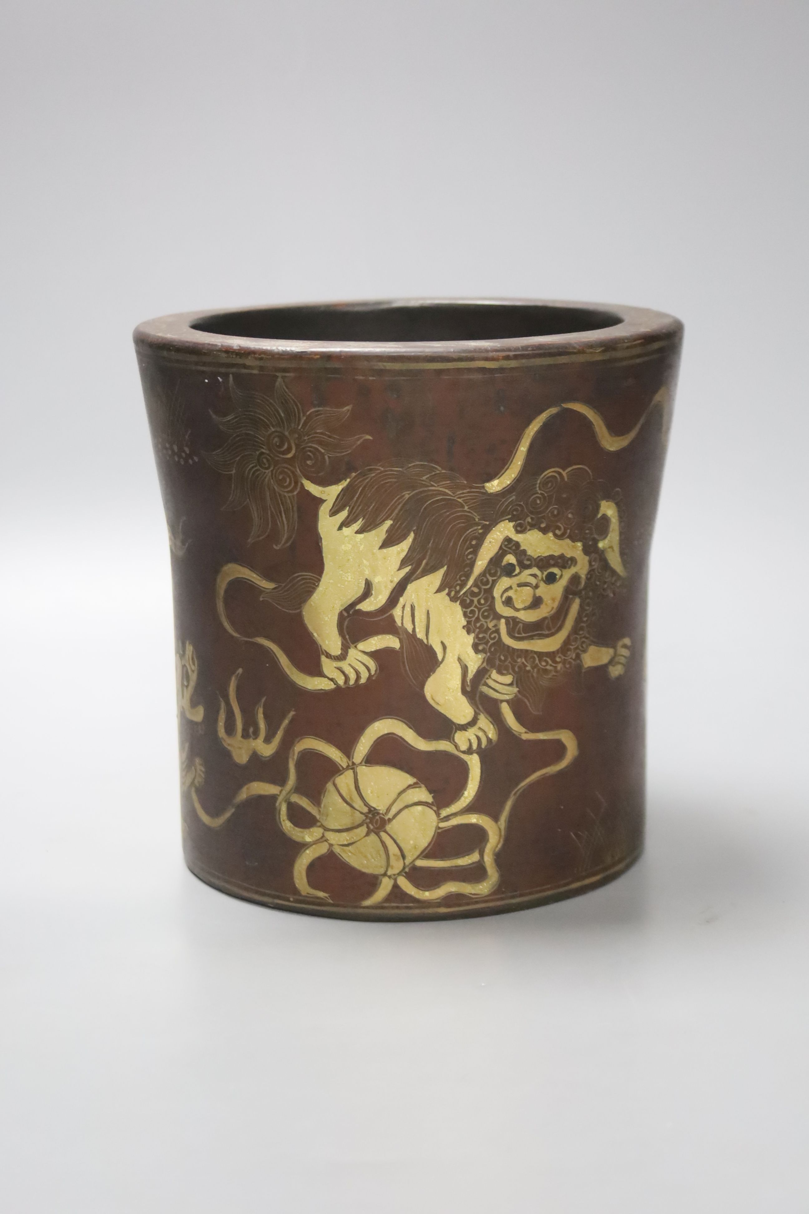 A Chinese lacquered brush pot / bitong, with gilt decoration of temple lions, character marks to underside, 16cm diameter 16cm high